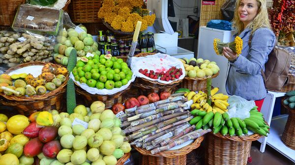 Покупательница выбирает фрукты и сахарный тростник