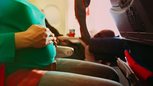 Беременная женщина в салоне самолета