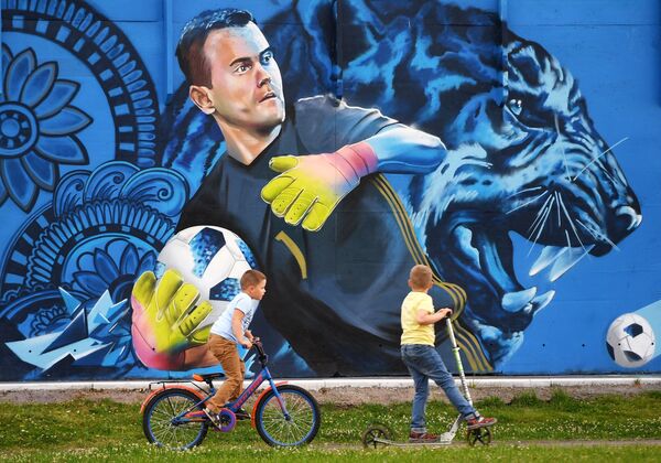 Дети рассматривают граффити с изображением вратаря сборной России по футболу Игоря Акинфеева в Щелково