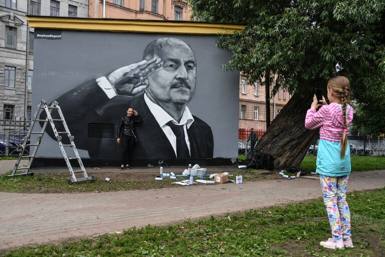 Девушка фотографируется у граффити с главным тренером сборной России по футболу Станиславом Черчесовым на трансформаторной будке в Пушкарском саду в Санкт-Петербурге