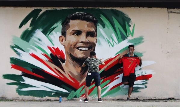 Болельщики рисуют граффити с изображением игрока сборной Португалии Криштиану Роналду перед матчем ЧМ-2018 по футболу между сборными Ирана и Португалии в Саранске