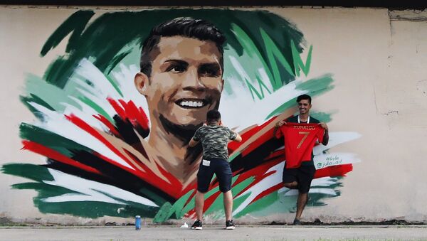 Болельщики рисуют граффити с изображением игрока сборной Португалии Криштиану Роналду перед матчем ЧМ-2018 по футболу между сборными Ирана и Португалии в Саранске