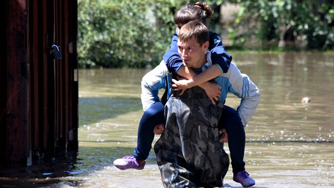 Местные жители на улице Лазо в Чите, затопленной в результате притока воды в реке Читинка.  10 июля 2018