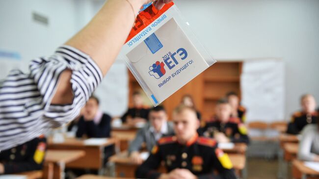 Преподаватель демонстрирует пакет и компакт-диск с заданиями перед началом ЕГЭ по математике в Екатеринбурге