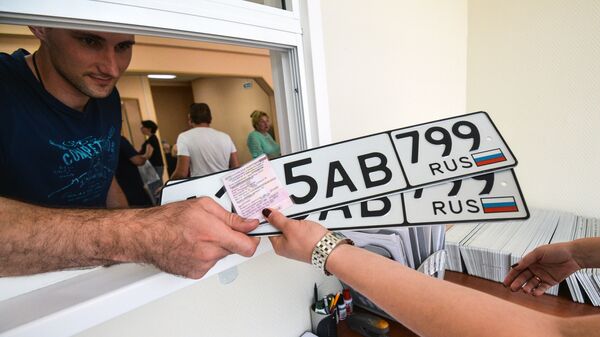 Выдача автовладельцу номерных знаков в одном из отделов регистрации транспортных средств ГИБДД по Москве. Архивное фото
