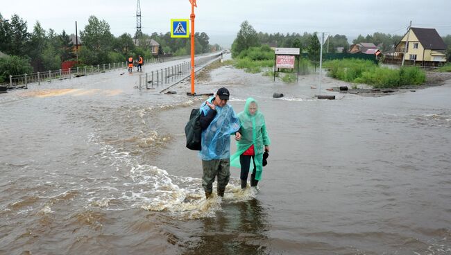 Местные жители на затопленной в результате паводка улице в Чите. 11 июля 2018