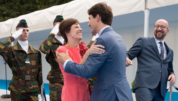 Премьер-министр Канады Джастин Трюдо приветствует гражданскую жену премьер-министра Бельгии Шарля Мишеля. 11 июля 2018