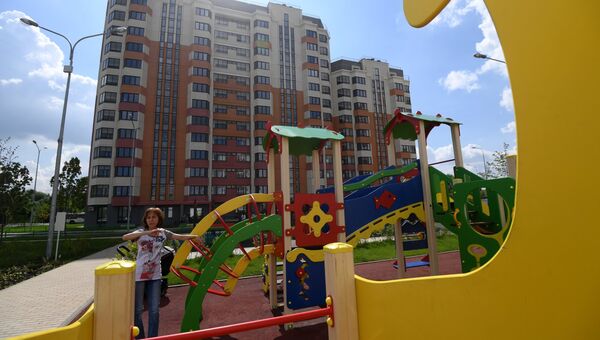 Детская площадка у многоэтажного жилого дома, предназначенного для переселения участников программы реновации. Архивное фото
