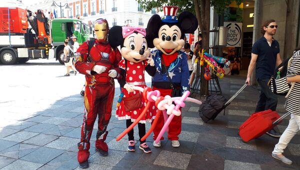 Живые статуи Железного человека, Минни и Микки маусов на улице Мадрида. 13 июля 2018