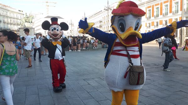 Люди в костюмах Микки Мауса и Дональд Дака на площади в Мадриде