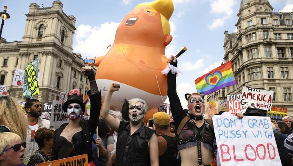 Люди держат плакаты во время акции против визита президента США Дональда Трампа в Великобританию на Площади Парламента в Лондоне. 13 июля 2018