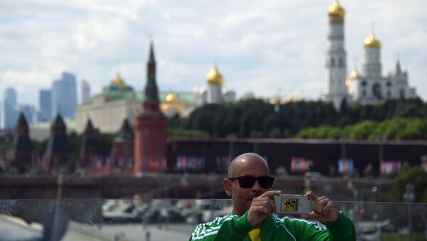 Турист фотографируется на фоне Кремля в Москве