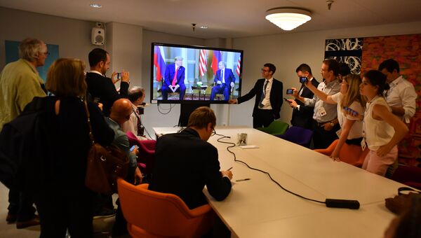 Журналисты смотрят трансляцию встречи президента РФ Владимира Путина и президента США Дональда Трампа в Хельсинки. 16 июля 2018