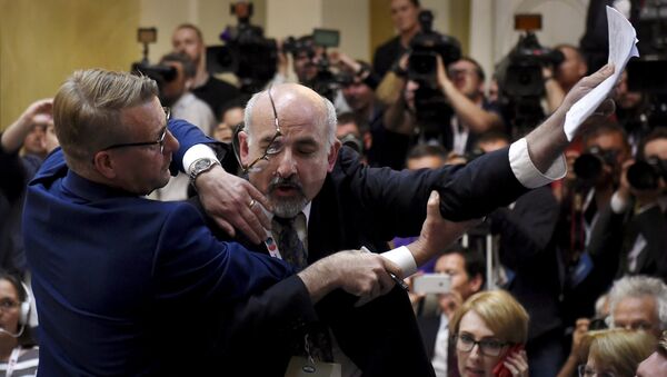 Сотрудники безопасности выводят журналиста перед совместной пресс-конференцией президента России Владимира Путина и президента США Дональда Трампа, Хельсинки. 16 июля 2018