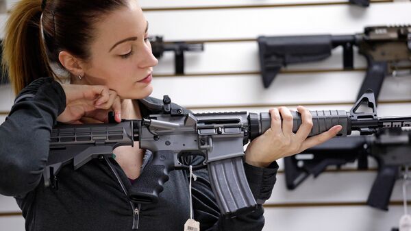 Девушка с автоматической винтовкой в магазине по продаже оружия в США