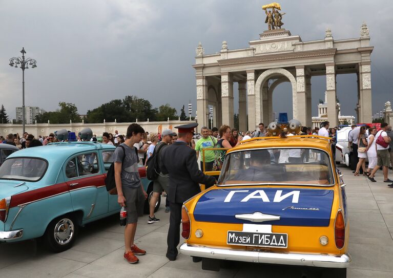 Люди рассматривают автомобили на выставке ретротехники, приуроченной к празднованию Дня московского транспорта, на ВДНХ в Москве