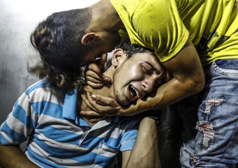 Палестинцы в морге оплакивают подростков, погибших в результате авиаудара Израильской армии