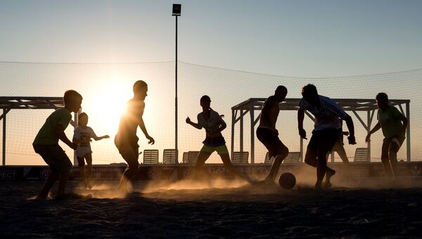 Отдыхающие на пляже играют в футбол в поселке Оленевка