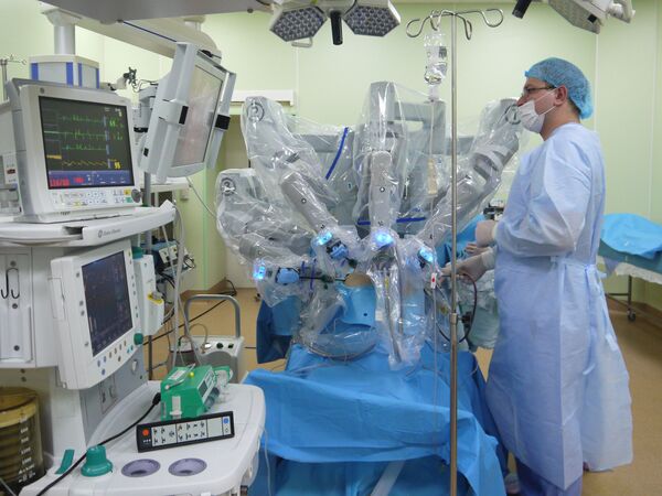 Робот-хирург приступает к операции. Ассистент профессора Михаила Еникеева, стоящий у операционного стола, следит за состоянием пациента
