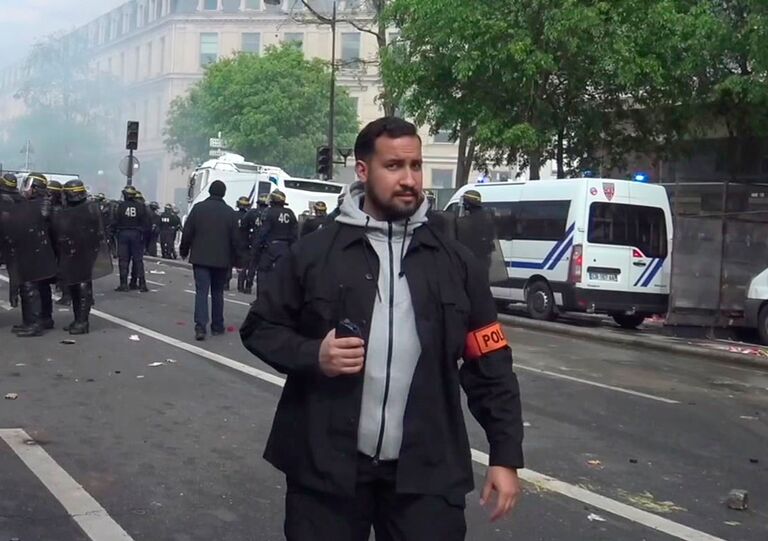 Советник президента Франции Александр Беналля во время столкновений с активистами на майском митинге в Париже