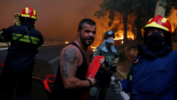 Пожарные во время борьбы с огнем в городе Рафина в Греции. 23 июля 2018