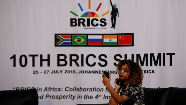 Девушка на фоне логотипа саммита BRICS-2018