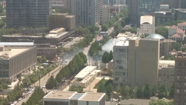Дым поднимается над улицей в Пекине после инцидента у посольства США. 26 июля 2018