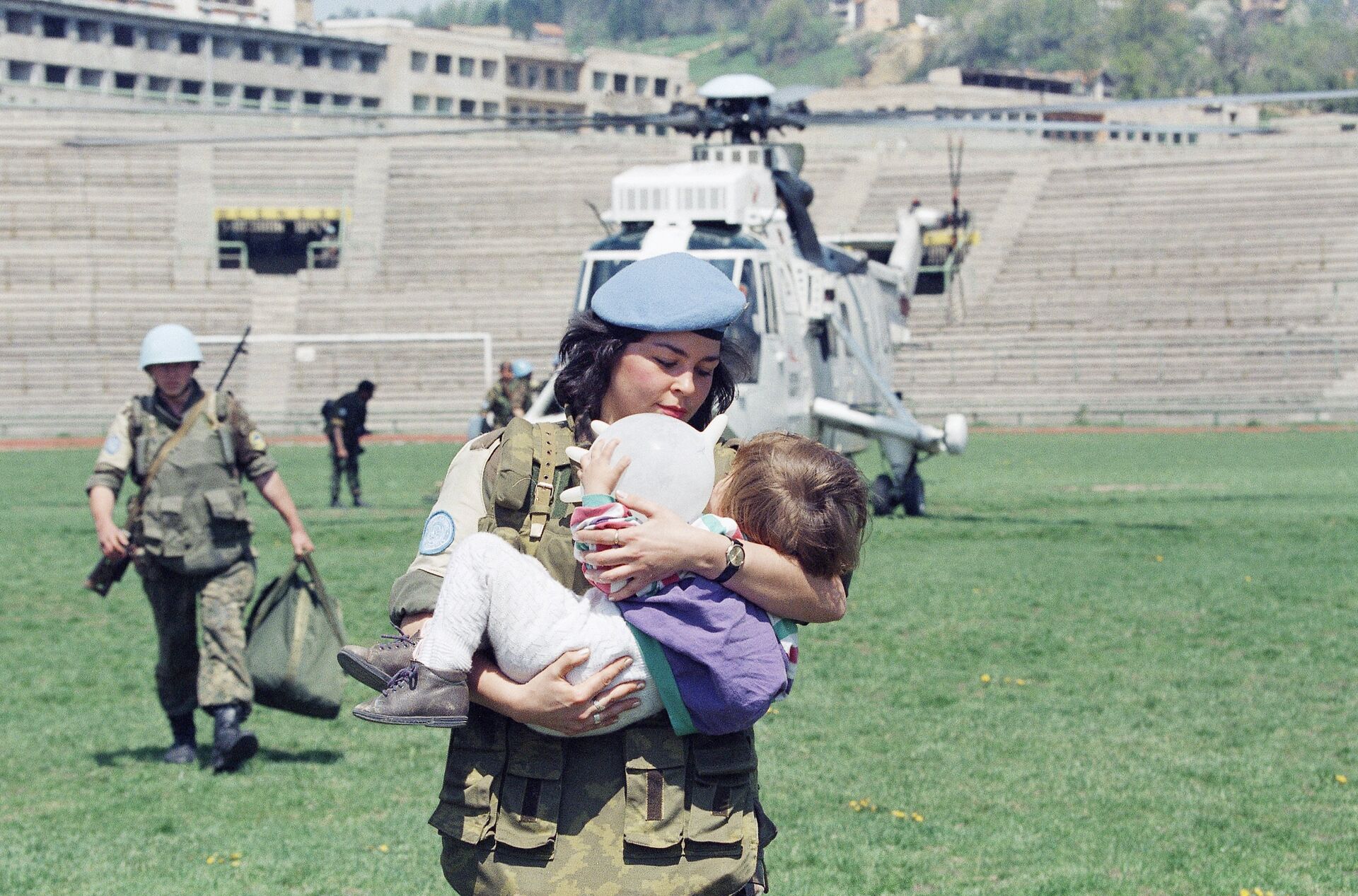 Женщина-солдат ООН несет двухлетнюю девочку, которую эвакуировали из города Горажде в Сараево, 25 апреля 1994 года - РИА Новости, 1920, 06.08.2021