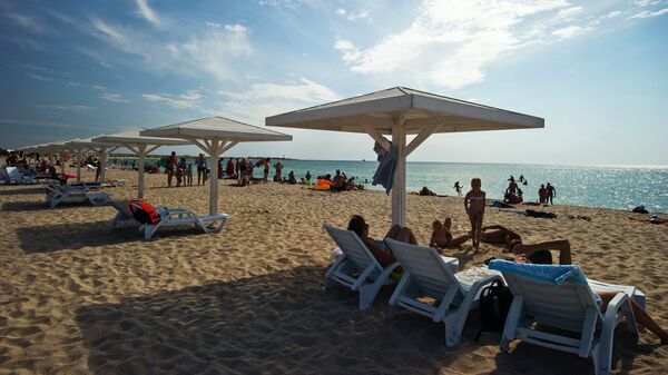 Отдыхающие на пляже на берегу Черного моря в поселке Оленевка на мысе Тарханкут в Крыму