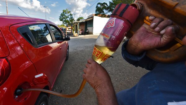 Заправка автомобиля бензином на границе Венесуэлы и Колумбии. Архивное фото