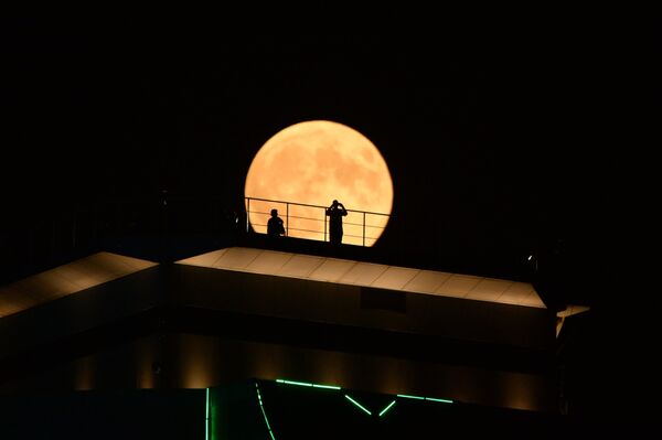 Луна во время затмения на фоне здания высотного комплекса Грозный сити в Грозном