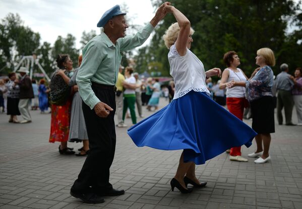 Пожилые люди танцуют в парке Березовая роща в Новосибирске