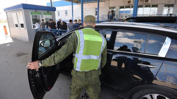 Сотрудник пограничной службы во время осмотра автомобиля на пограничном контрольно-пропускном пункте Бугристое российско-казахстанской границы