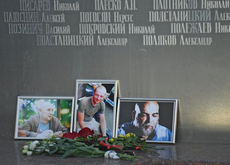 Цветы у фотографий погибших в Центральноафриканской Республике журналистов: Орхана Джемаля, Кирилла Радченко и Александра Расторгуева возле Дома журналистов в Москве. 1 августа 2018