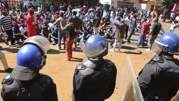 Полиция и участники протеста в Хараре в Зимбабве. 1 августа 2018