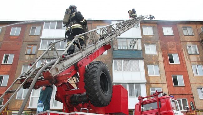 Сотрудники МЧС во время ликвидации пожара на крыше жилого дома в Кемерово. 2 августа 2018