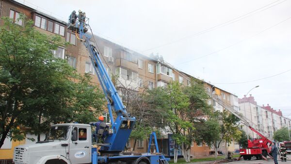 Сотрудники МЧС во время ликвидации пожара на крыше жилого дома в Кемерово. 2 августа 2018