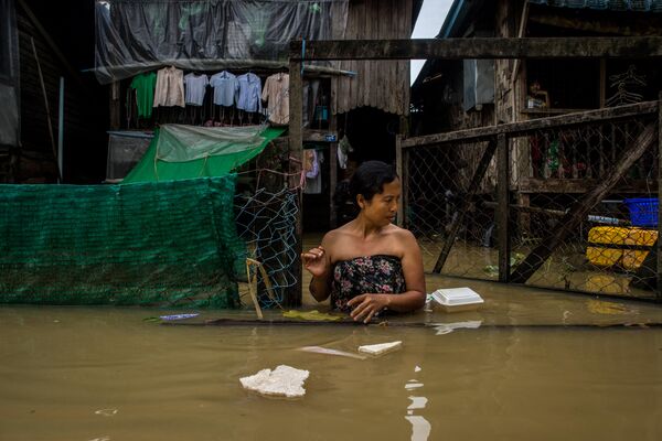 Девушка на улице города Баго во время наводнения в Мьянме.