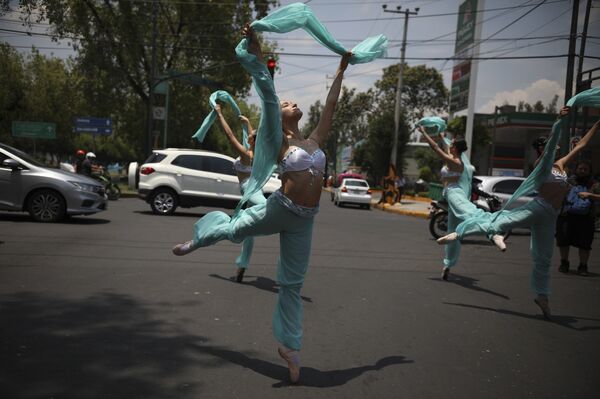 Балерины танцуют во время красного сигнала светофора в Мехико.