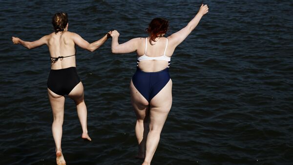 Девушки прыгают в море в Хельсинки. 30 июля 2018 года