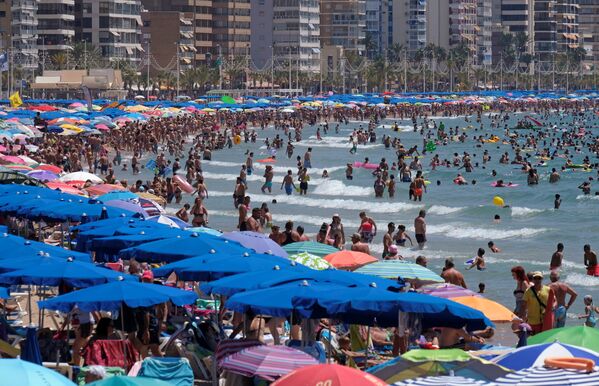 Люди на пляже в городе Бенидорм, Испания.