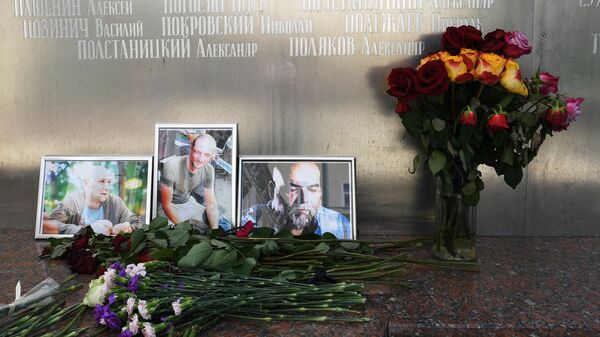 Цветы у фотографий погибших в Центральноафриканской Республике российских журналистов возле Дома журналистов в Москве