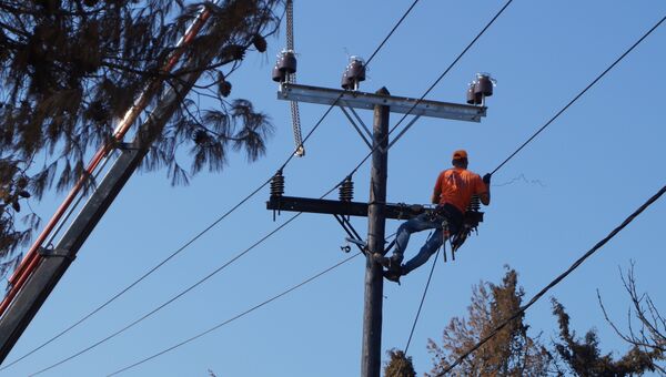 Рабочие меняют провода на линиях электропередачи