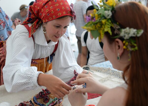 Посетители во время мастер-класса по изготовлению кукол на фестивале Многонациональная Россия в Москве