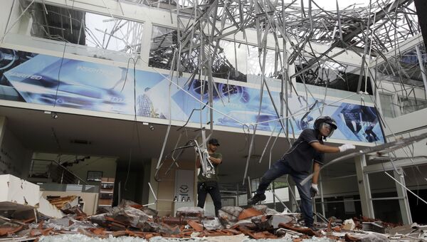 Рабочие разбирают завалы в здании, поврежденном землетрясением на Бали, Индонезия. 6 августа 2018