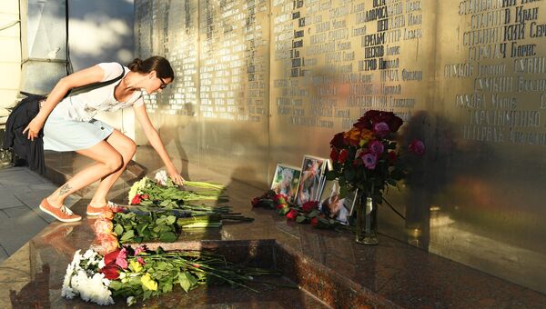 Девушка возлагает цветы у фотографий погибших в Центральноафриканской Республике  журналистов возле Дома журналистов в Москве