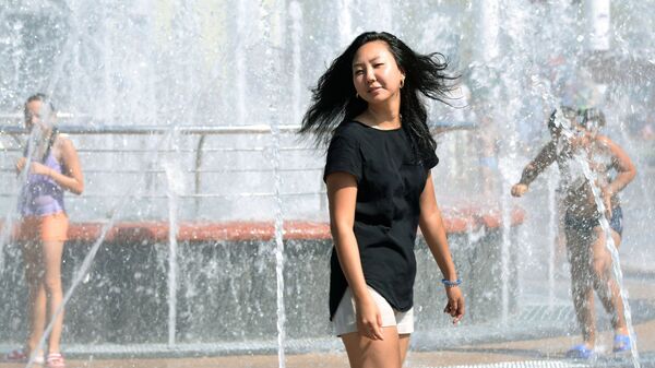 Девушка охлаждается в сухом фонтане на набережной стадиона имени Ленина в Хабаровске