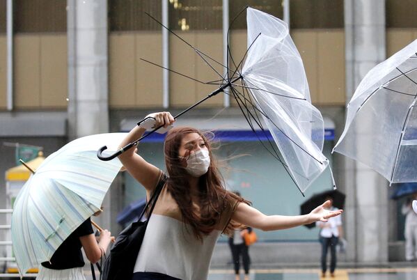Девушка с зонтом во время приближения тайфуна Шаньшань в Токио. 8 августа 2018 года