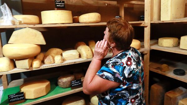 Покупательница выбирает сырную продукцию фермера Джея Роберта Клоуза в магазине при ферме в Московской области, деревни Мошницы