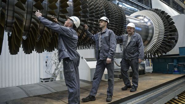 Рабочие ООО Сименс технологии газовых турбин осматривают ротор с лопатками в цехе по восстановлению лопаток газовых турбин